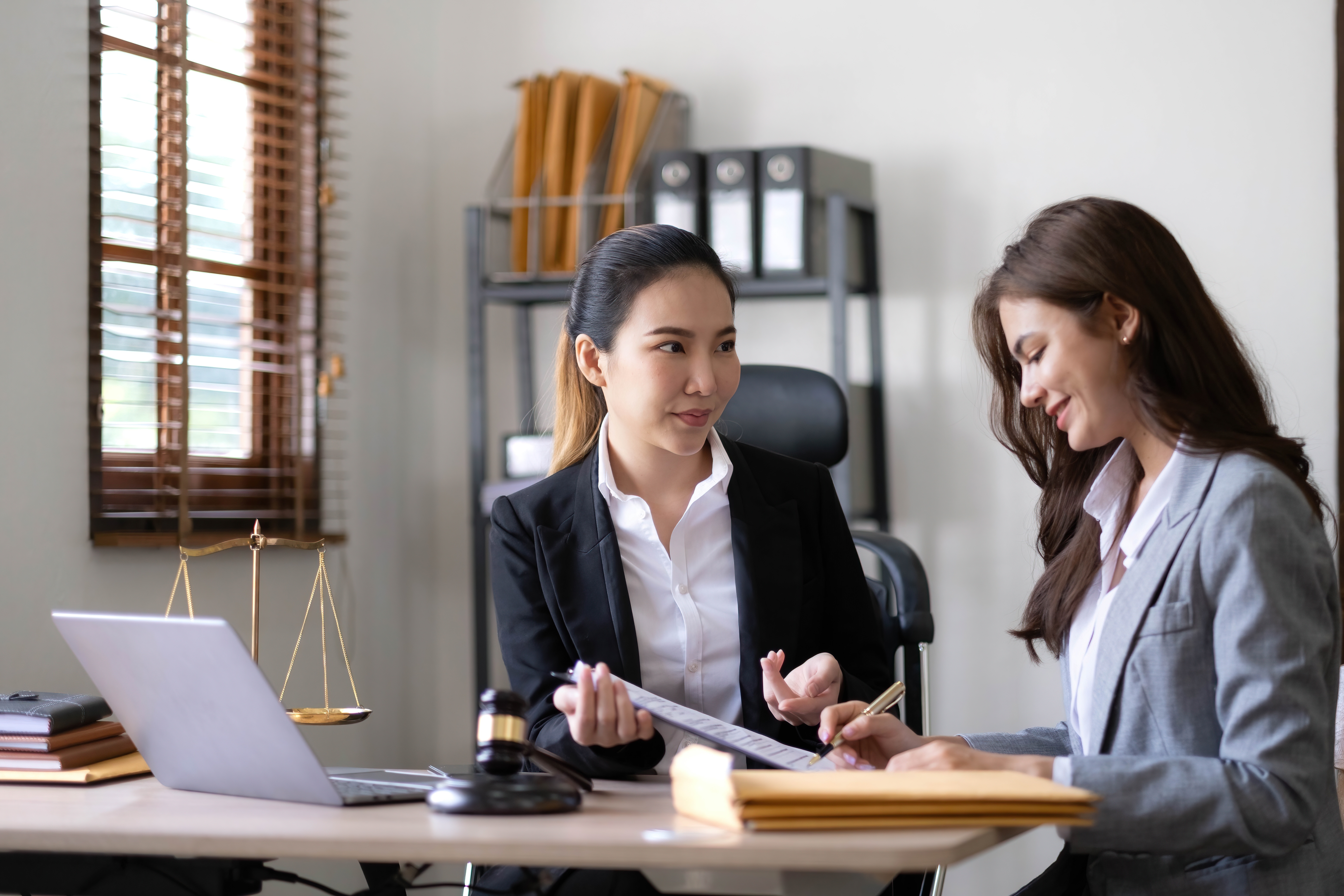 Two business women working on a document together.