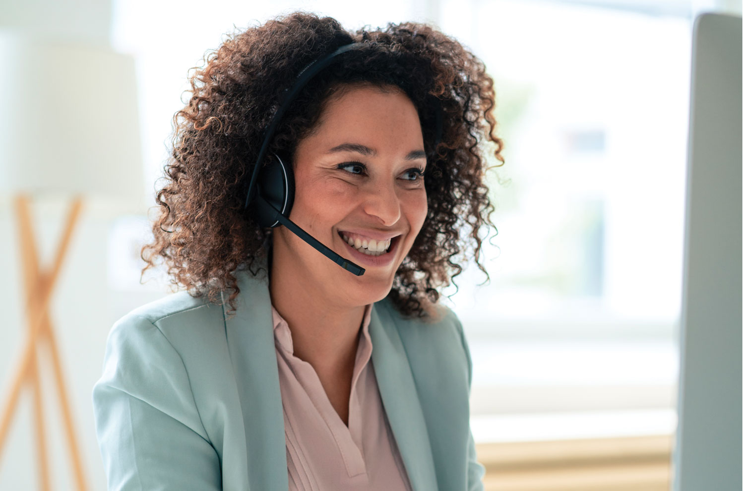 Businesswoman working on computer while wearing headset speaker