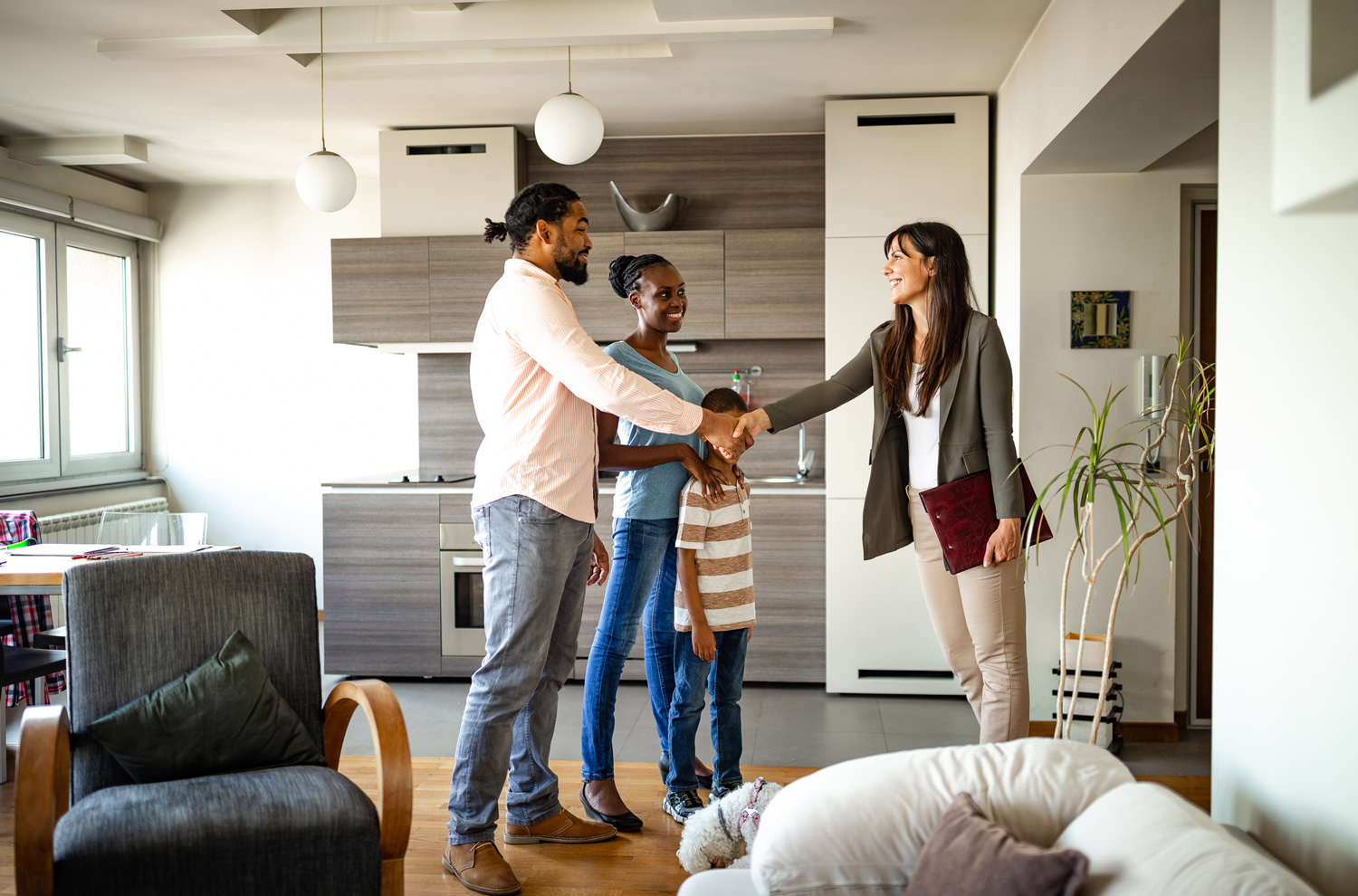Real estate agent with family standing inside house for sale