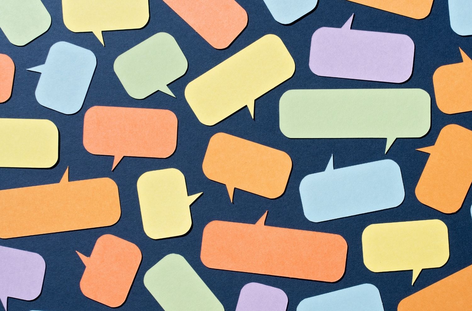 Thought bubble paper cutouts scattered atop blue paper
