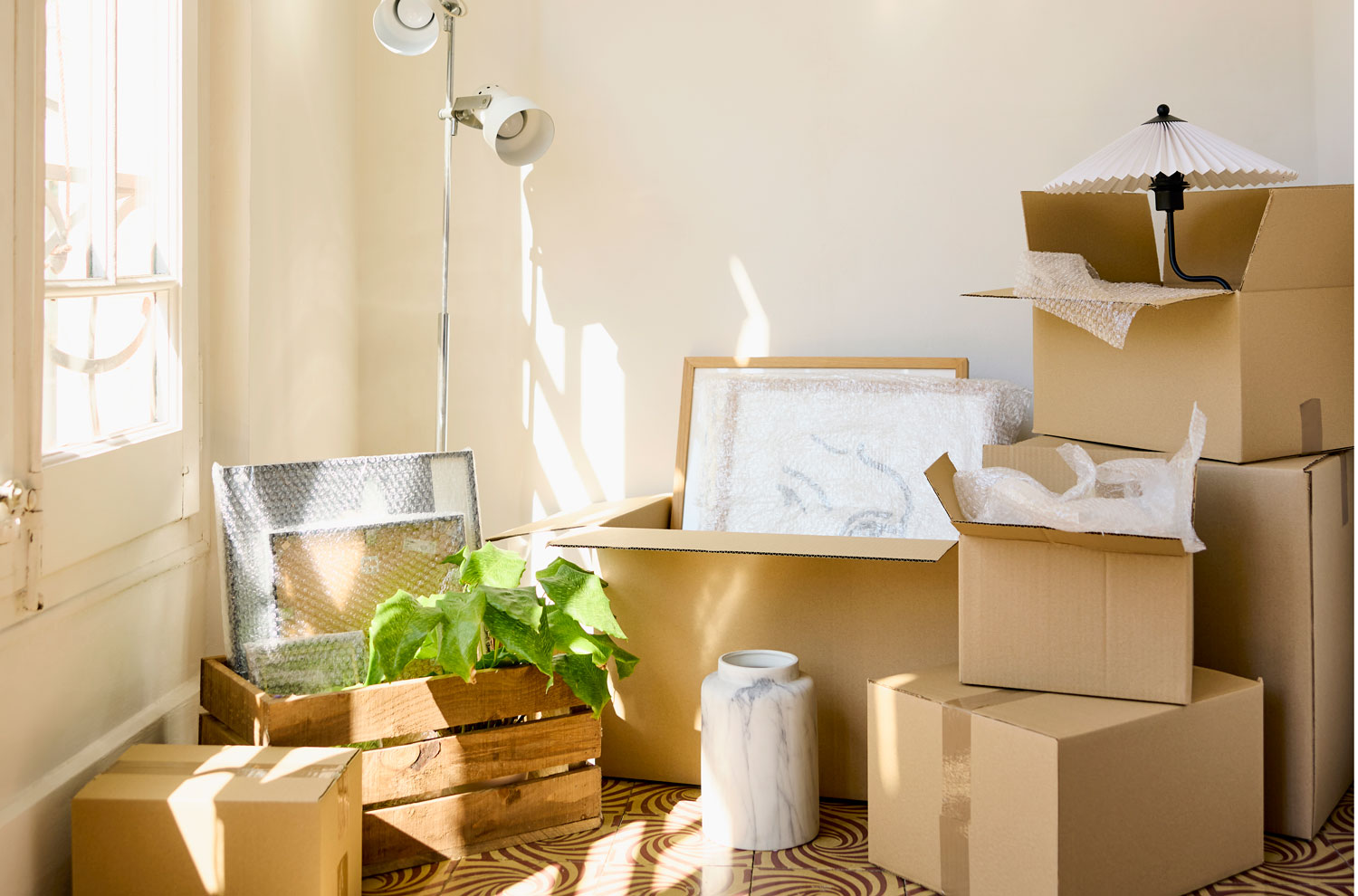 Moving boxes and crates next to sunlit window
