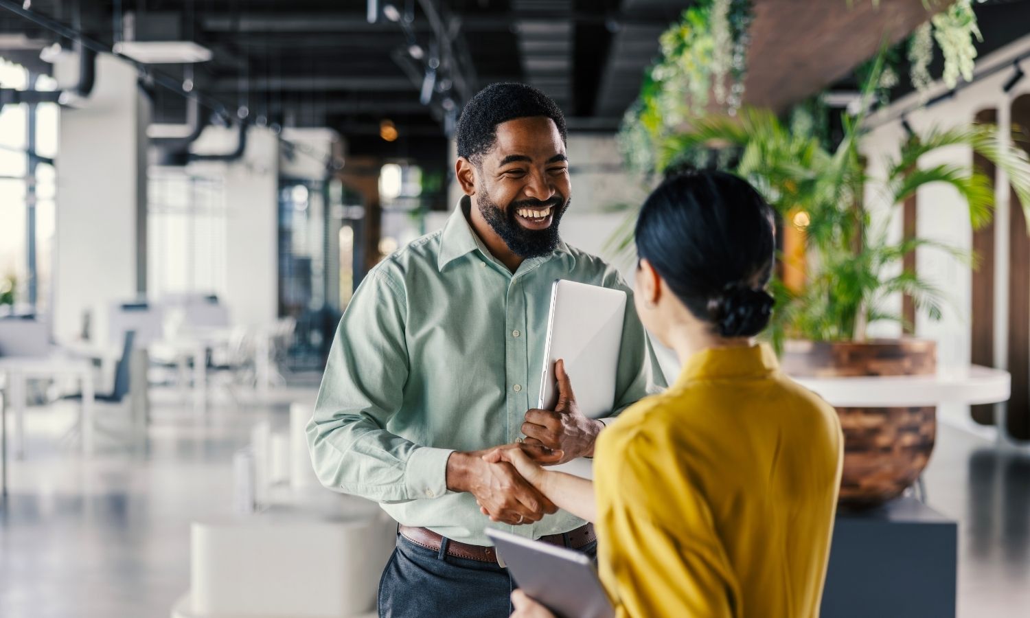Two businesspeople shaking hands in restaurant setting