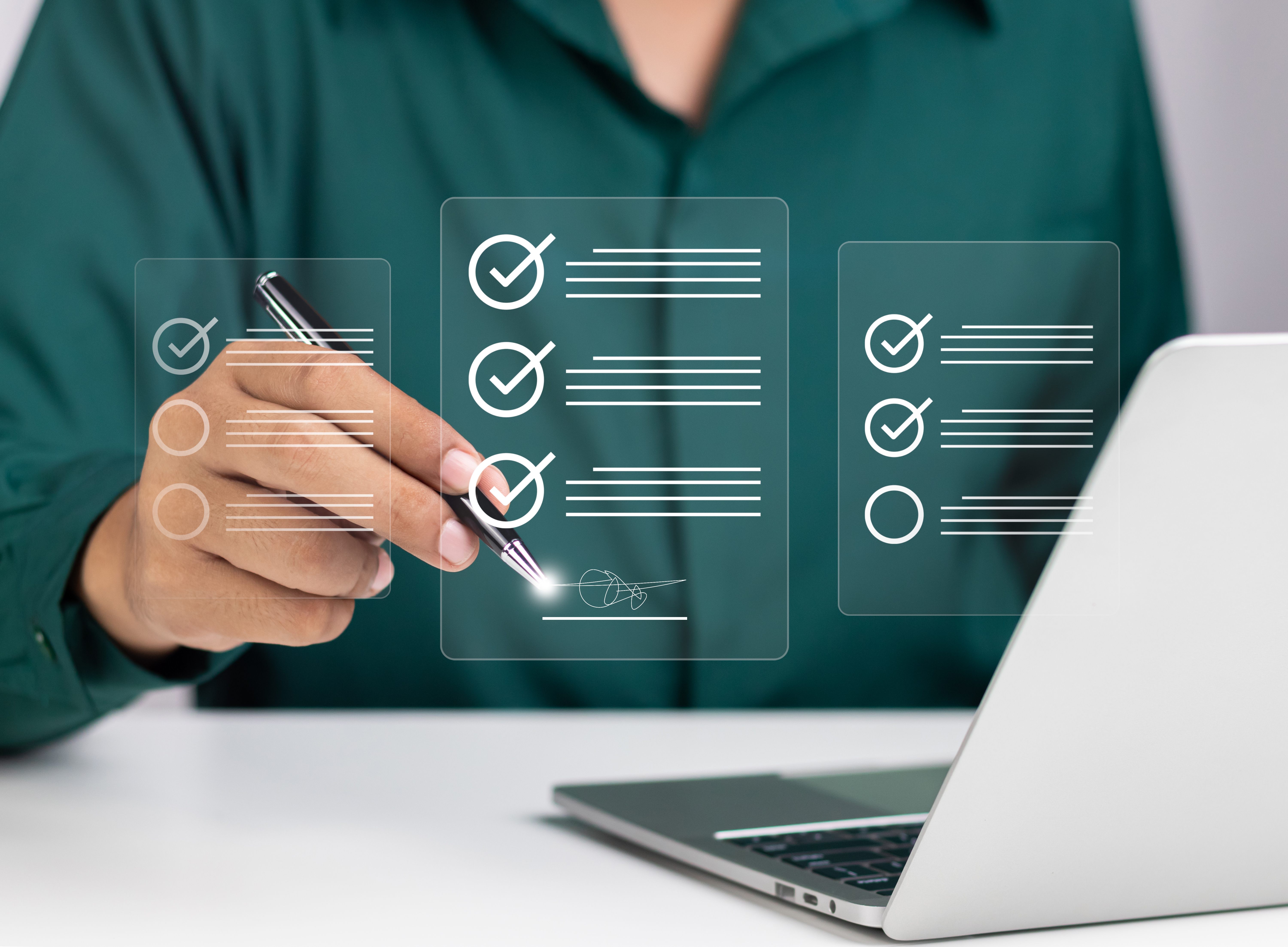 Person e-signing a digital form in the air above their computer as to show that going paperless is as easy as writing in the air.
