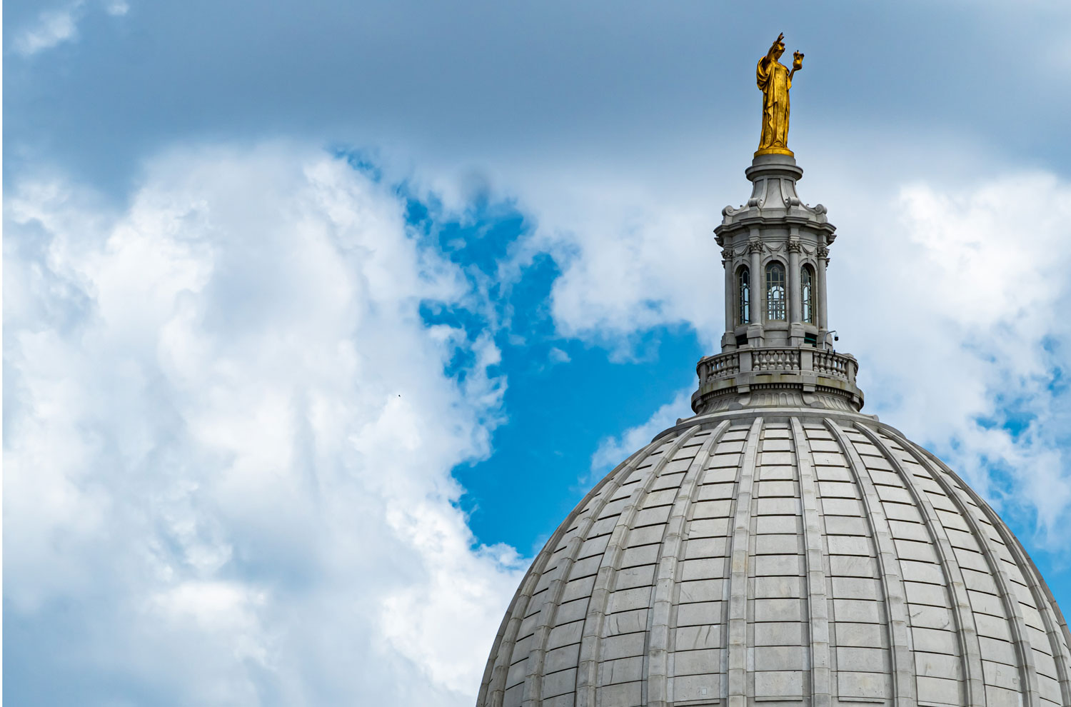 Wisconsin Capitol building exterior dome with clouds in the background
