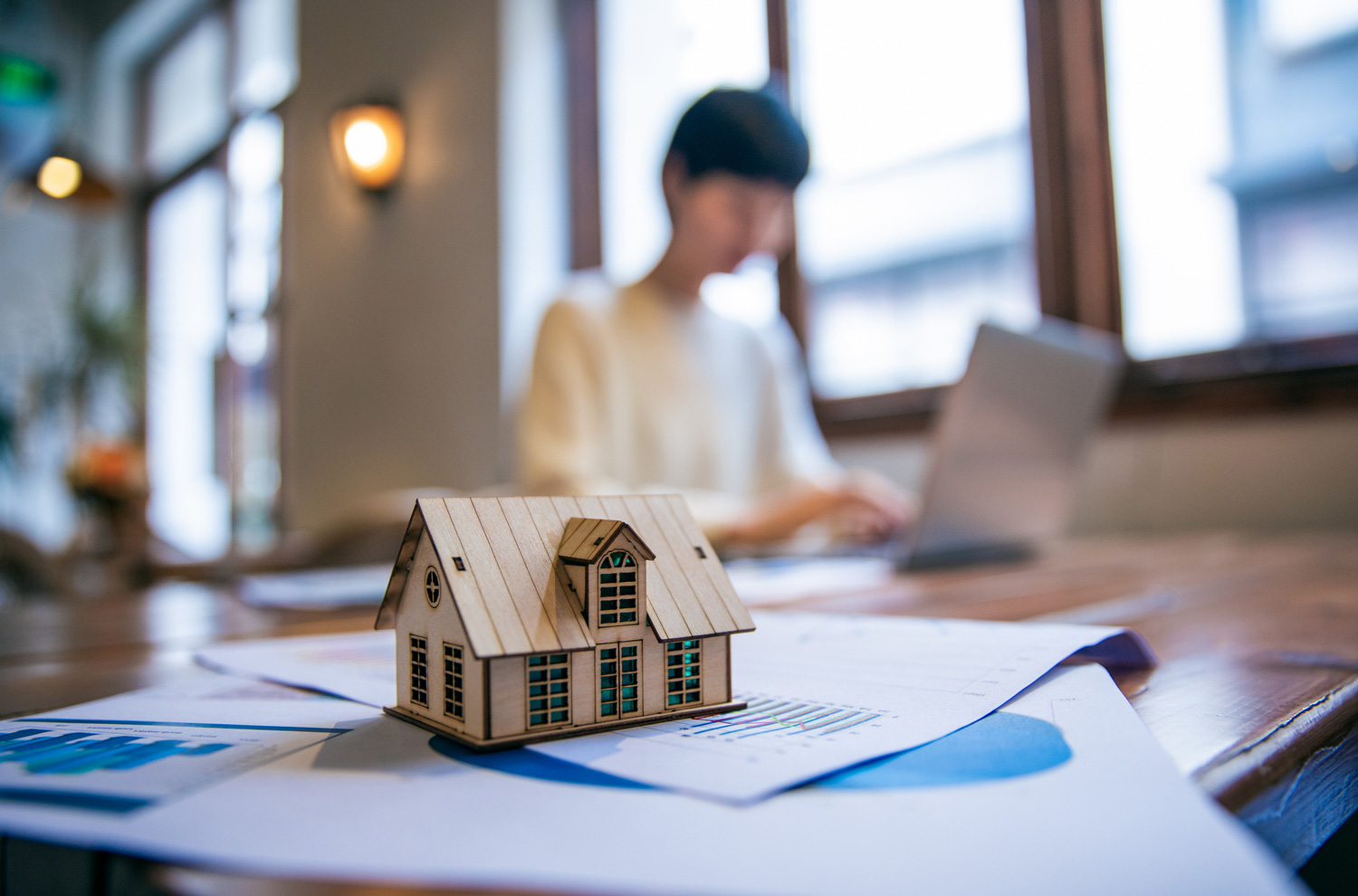 Model house sitting on desk with paperwork